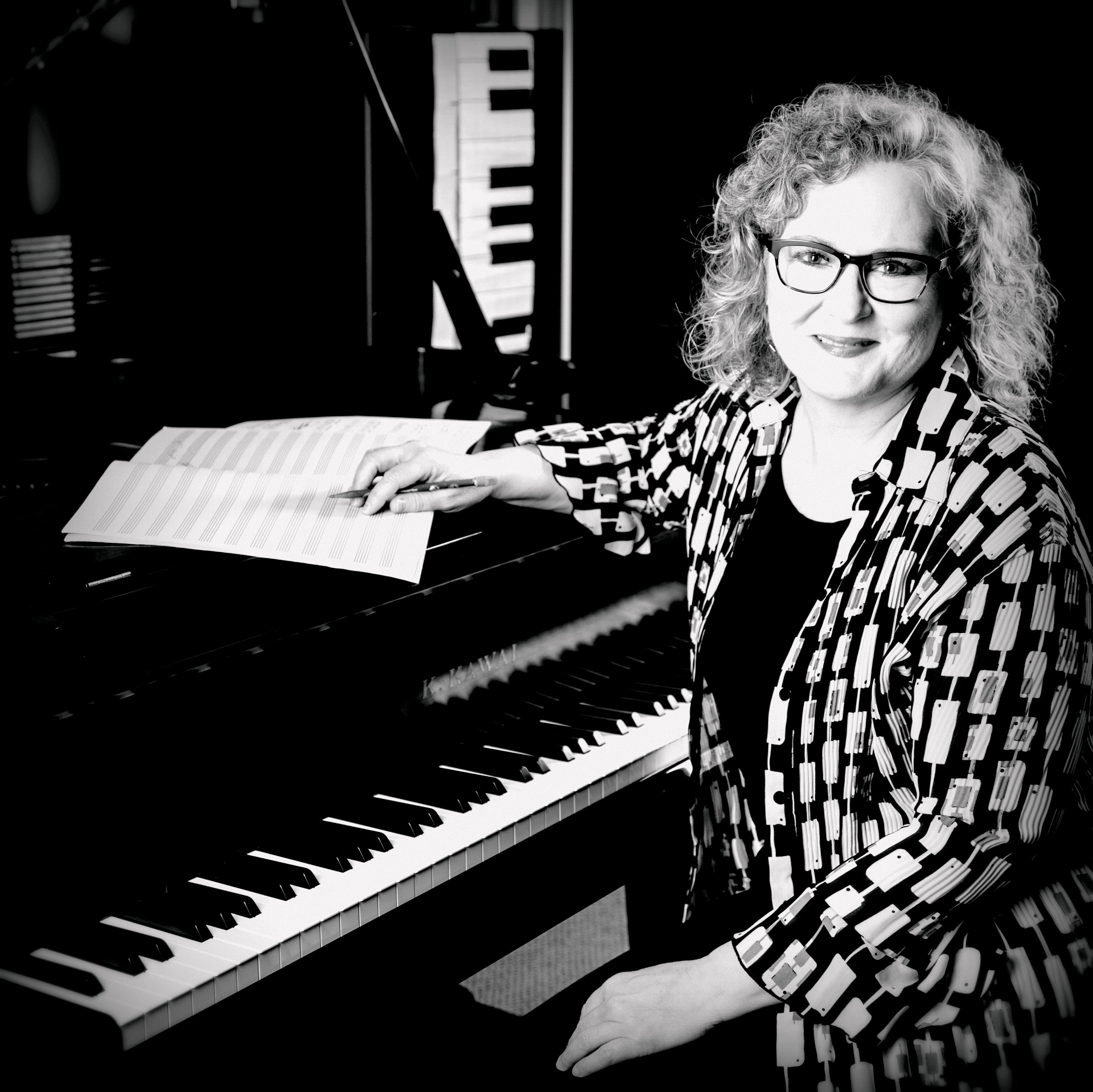 photo of Dianne seated at her piano, composing